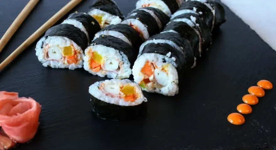 Roladki sushi z surimi, marchewką i papryką. Czy surimi jest zdrowe? Zależy od składu i sposobu przygotowania.