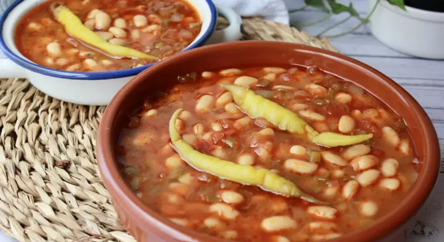 Dos cuencos de pochas a la navarra, un plato reconfortante con judías blancas, tomate y pimientos.