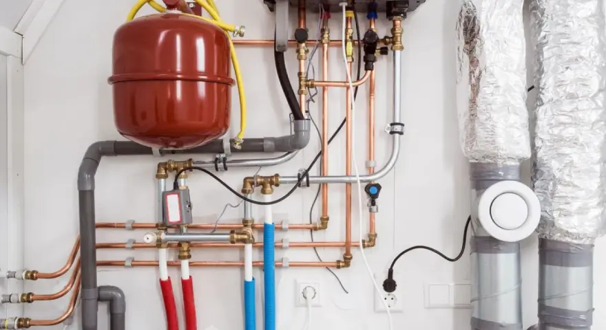 System ogrzewania z kotłem, zasobnikiem i miedzianą armaturą. To pokazuje, co to jest armatura w praktyce.
