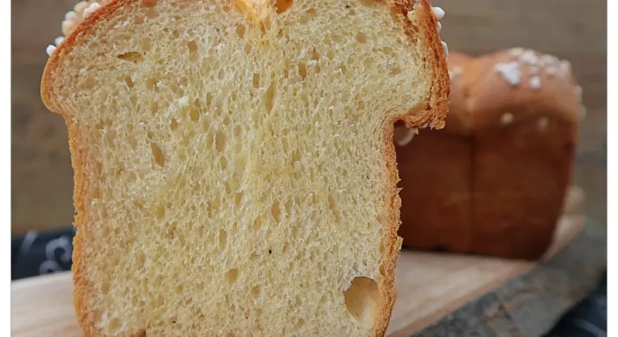 Schnitt von einem goldbraunen Brioche-Brot, perfekt für Lievito Madre Rezepte. Die weiche Krume mit kleinen Luftlöchern und die süße Kruste laden zum Genuss ein.