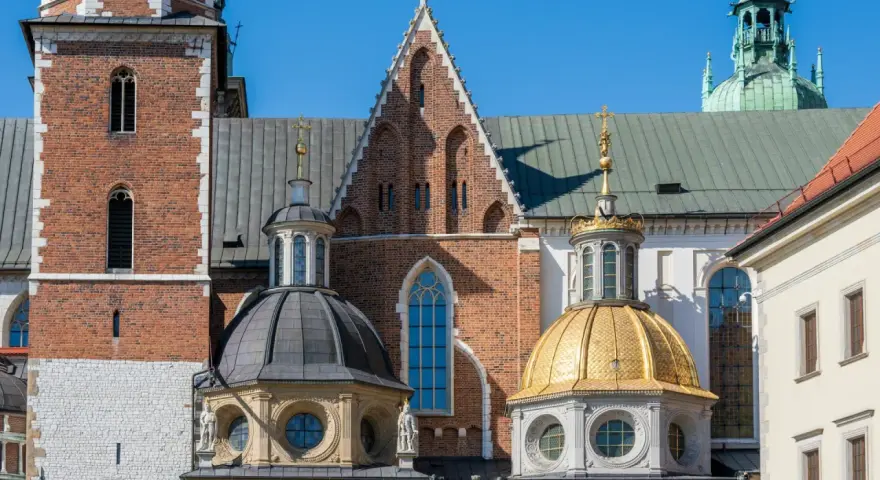 Wawel, jeden z najpiękniejszych zamków w Małopolsce, z charakterystycznymi kopułami i ceglaną wieżą.