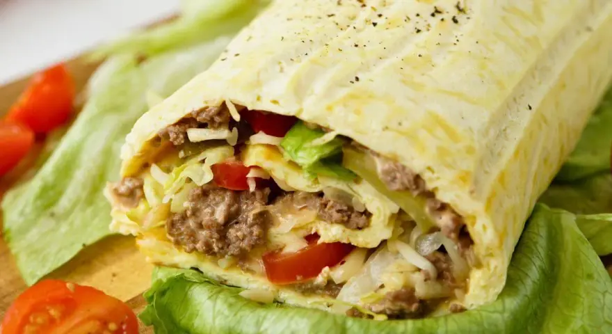 Herzhafte Big Mac Rolle gefüllt mit Hackfleisch, Salat, Tomaten und Käse, serviert auf knackigem Salatblatt.