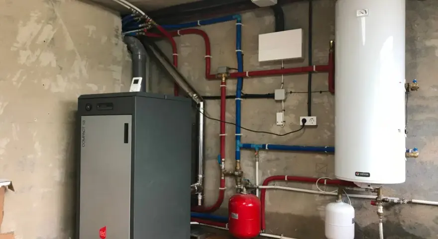Instalación de caldera de pellets para radiadores, con depósito de agua caliente y sistema de tuberías.