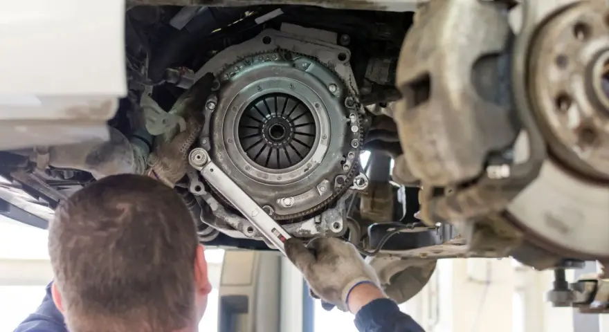 Mechanik dokręca śruby docisku sprzęgła. Wymiana sprzęgła krok po kroku w trakcie naprawy samochodu.