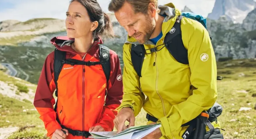 Wanderer prüfen die Route. Ihre wasserdichten Jacken schützen sie vor dem Wetter.