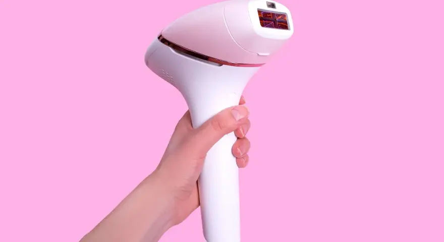 Biały depilator laserowy w dłoni. Dowiedz się, jak używać depilatora laserowego dla gładkiej skóry.