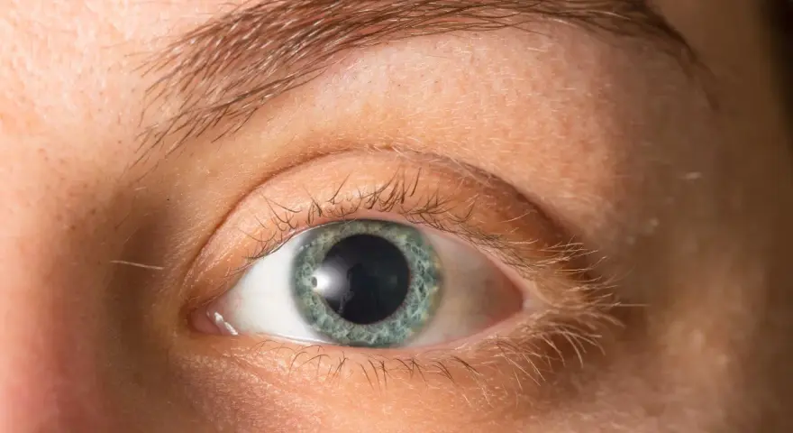 Occhio con iride azzurra e pupille dilatate, forse per l'emozione o la poca luce.