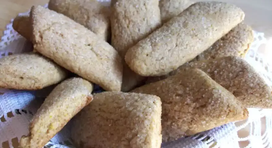 Un cesto pieno di biscotti della nonna, dorati e cosparsi di zucchero, invitano a un assaggio di dolcezza casalinga.