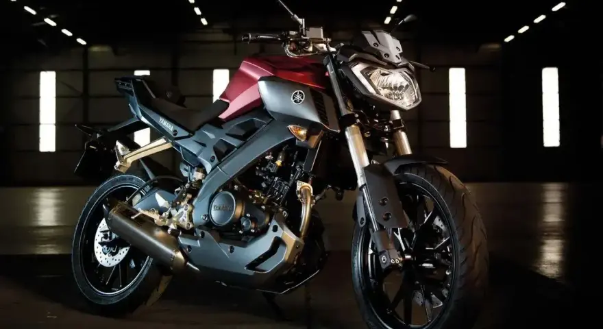 Czerwono-szary motocykl Yamaha TZR 125 V-Max w ciemnym pomieszczeniu.
