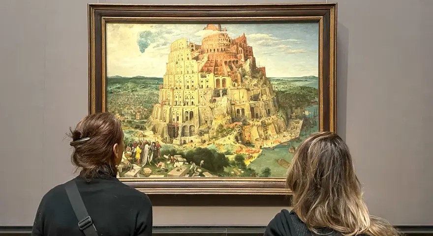Dwie osoby oglądają obraz Wieża Babel w Muzeum Historii Sztuki w Wiedniu.