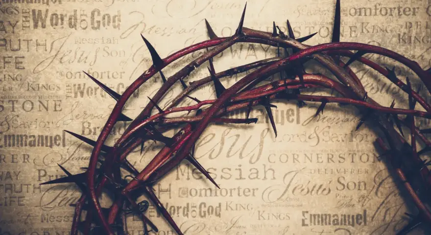 Dornenkrone auf Pergament mit Titeln wie "Jesus", "Messiah", "Savior". Sie symbolisiert die tiefe Jesus Christus Bedeutung und sein Leiden.