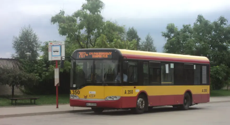 Autobus 707 z napisem "CM. POŁUDNIOWY BRAMA PŁD." czeka na pasażerów. Rozkład jazdy jest widoczny na przystanku.
