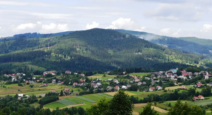 Letnia panorama Istebnej z górami i domkami. Idealne miejsce na wakacje, pełne atrakcji.