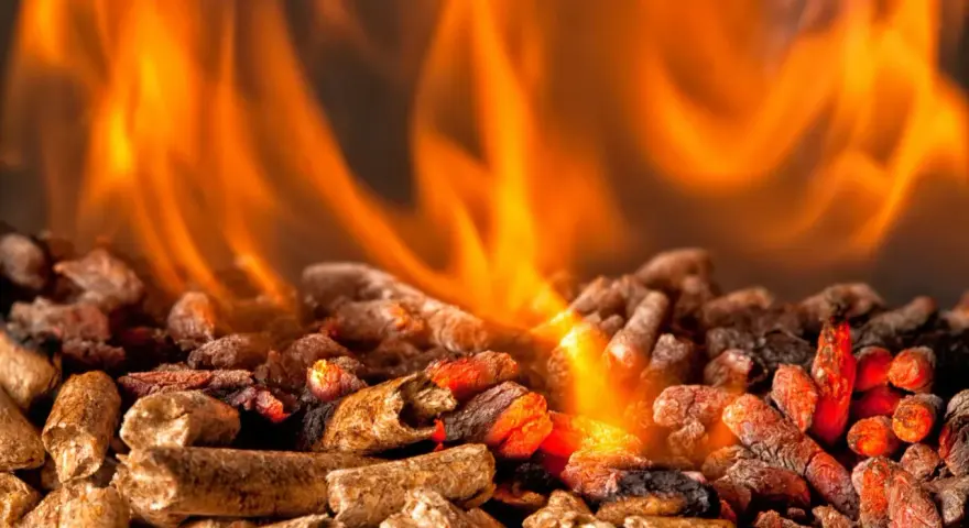 Fiamme arancioni danzano su un letto di pellet ardente. Per scaldare 100 mq, quanti kw servono?