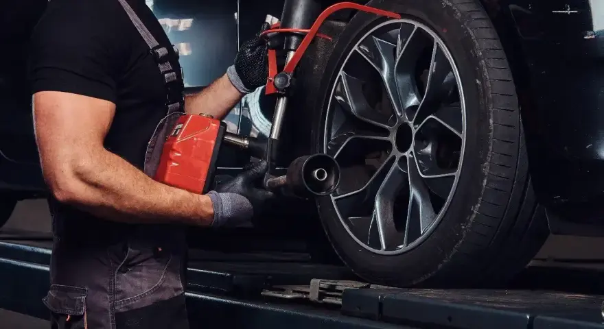 Mechanik sprawdza opony Kormoran, zastanawiając się, gdzie produkowane są te solidne opony.