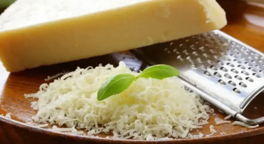 Tarty parmezan z bazylią i tarką. Czy parmezan jest wegetariański? Tradycyjnie nie, bo zawiera podpuszczkę zwierzęcą.
