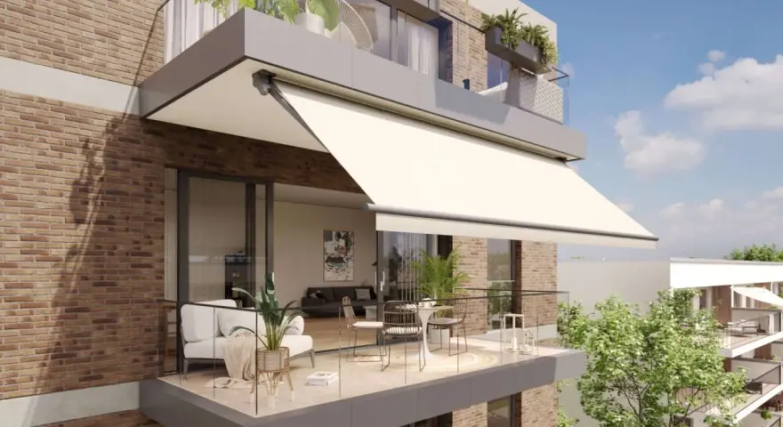 Balcón moderno con sofá, mesa y sillas, protegido por uno de los tipos de toldos más elegantes.