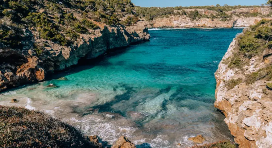 Cala des Moro, Majorka. Turkusowa woda obmywa skaliste wybrzeże, tworząc malowniczą zatoczkę.