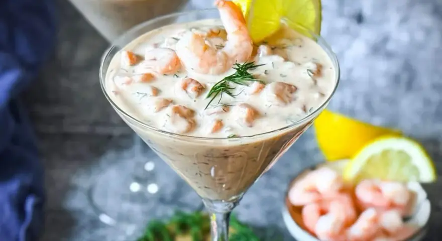 Ein cremiger Shrimp Cocktail in einem Martiniglas, garniert mit Dill und Zitrone. Ein köstlicher Genuss!
