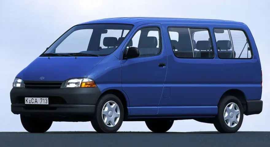 Niebieski van Toyota Hiace z lat 90. z widocznymi siedzeniami i oknami.