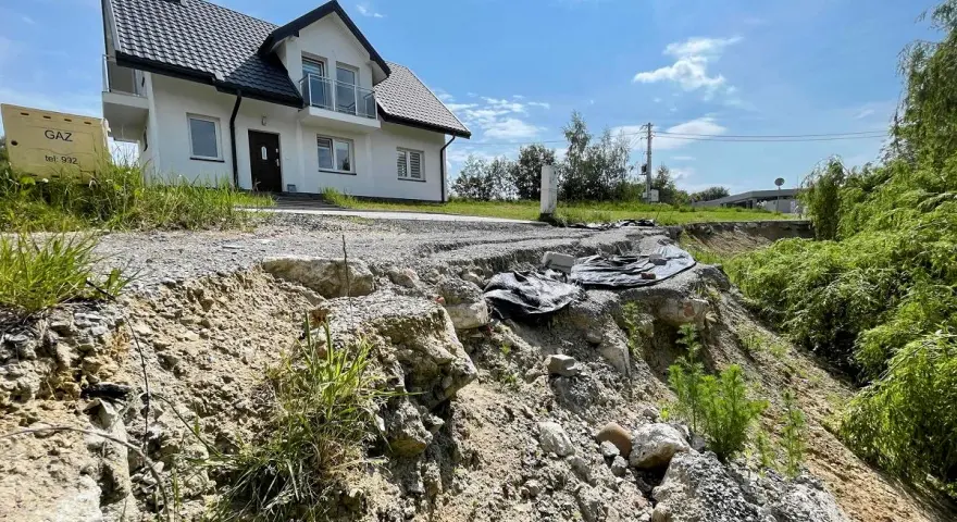 Nieaktywne osuwisko obok budowy domu. Teren niestabilny, droga częściowo zniszczona.