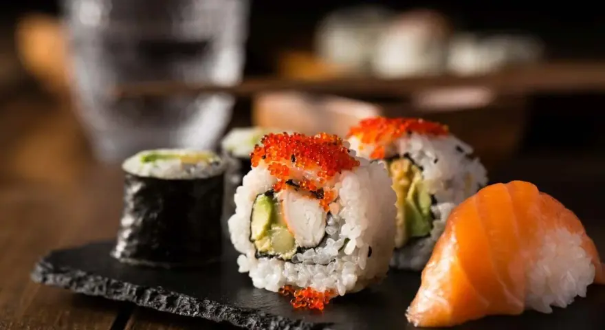 Pyszne rolki sushi z łososiem i kawiorową posypką, idealne na wieczór z przyjaciółmi. Co do sushi, to właśnie to!