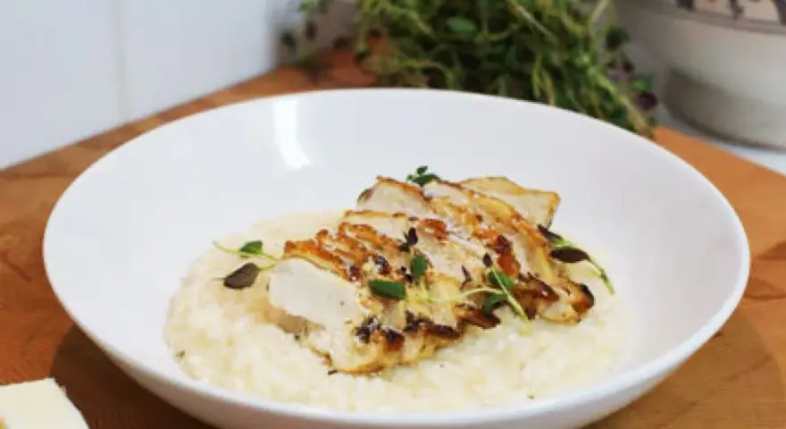En krämig risotto med kyckling, toppad med färska örter och en bit parmesan. En perfekt risotto med kyckling för en härlig middag.