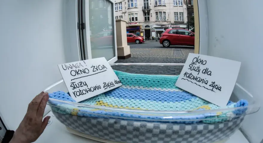 Okno życia, bezpieczne miejsce dla noworodków. Dwa napisy informują: "Uwaga! Okno życia służy ratowaniu życia dziecka" i "Okno służy dla ratowania życia".