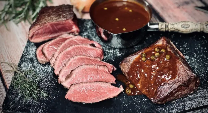 Saftiges Roastbeef mit einer cremigen Pfeffersauce, perfekt für ein festliches pfeffersauce rezept. Dazu frische Kräuter und eine Prise Salz.