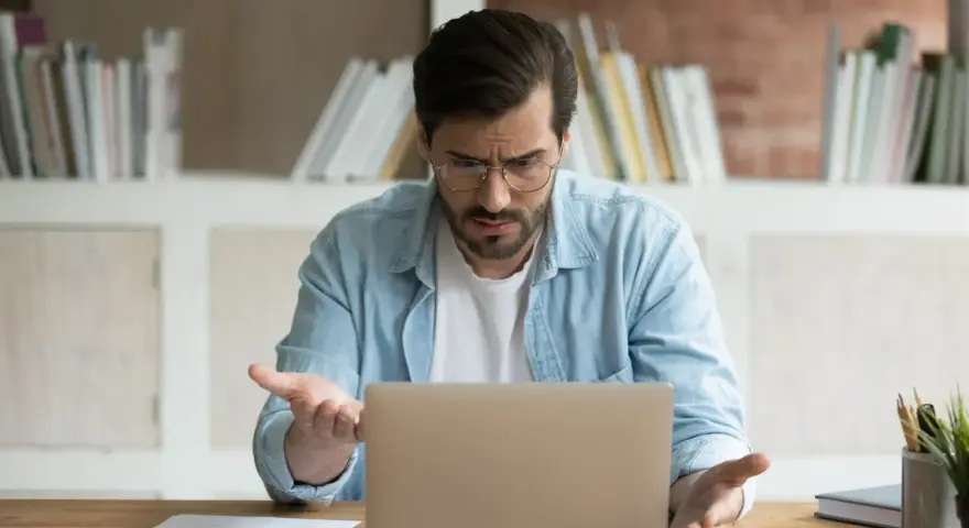 Zdezorientowany mężczyzna szuka w internecie, skąd wziąć wniosek o świadczenie wspierające.