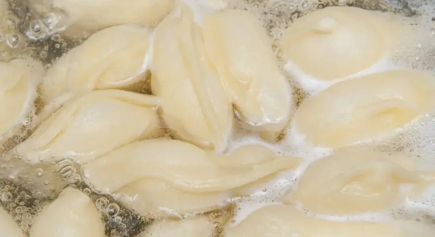 Pierogi gotujące się w bulgoczącej wodzie.