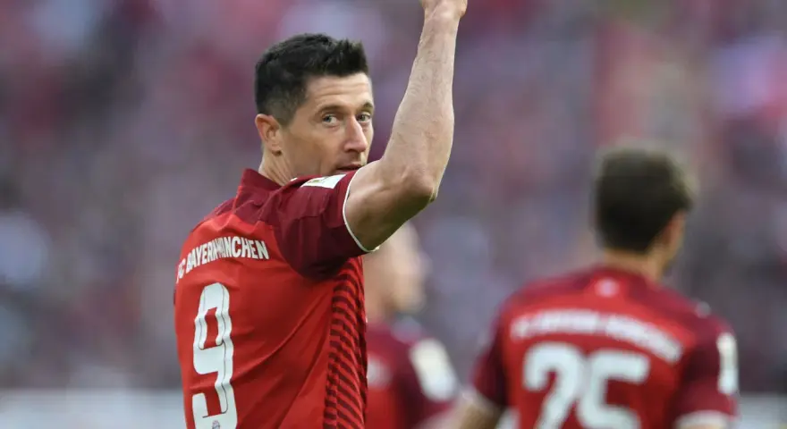 Piłkarz Robert Lewandowski w czerwonej koszulce z numerem 9 świętuje bramkę.