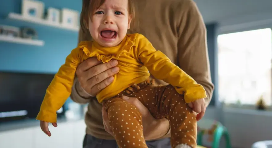 Ein weinendes Kind (2 Jahre) wird von seinem Vater gehalten. Es sagt "Mama weg!" und ist untröstlich.