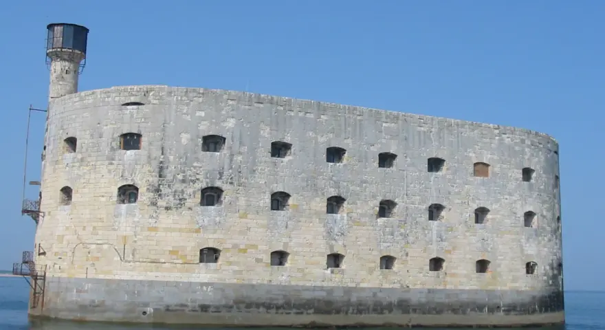 Fort Boyard, imponująca kamienna twierdza na wodzie, z licznymi oknami i wieżą.