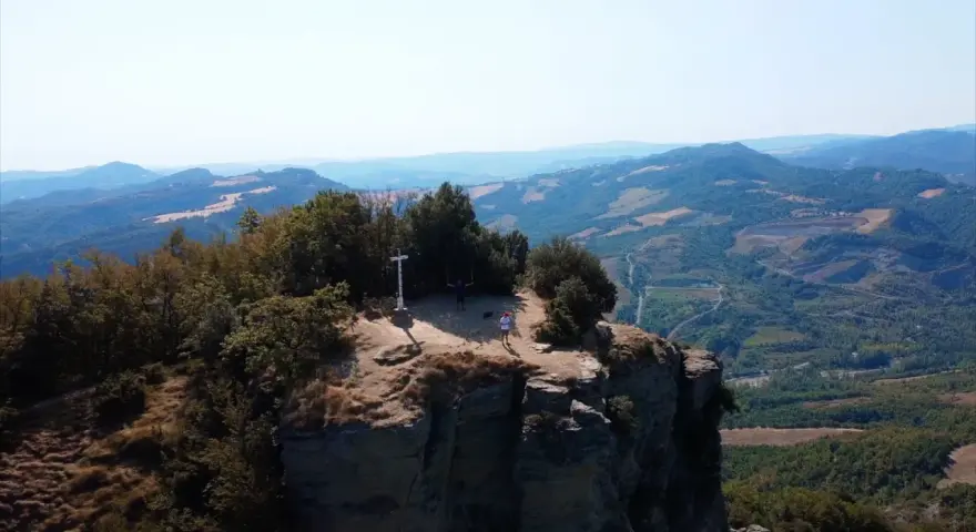 Due escursionisti celebrano la vetta raggiunta sul crinale, un momento clou del cammino della Via degli Dei in 5 giorni.