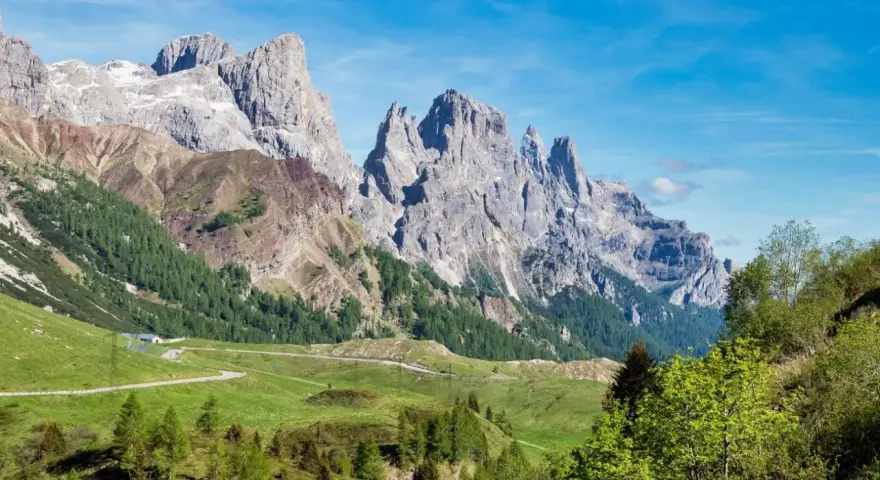 Panorami mozzafiato al Passo Rolle, con imponenti vette rocciose che si stagliano contro il cielo azzurro. L'altitudine regala un'aria pura e una vista indimenticabile.