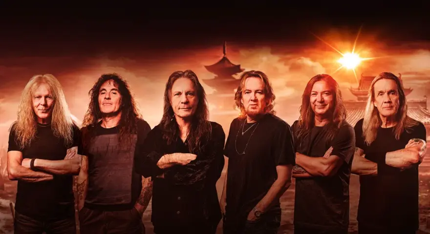 Les membres de Iron Maiden posent devant un paysage asiatique au coucher du soleil.