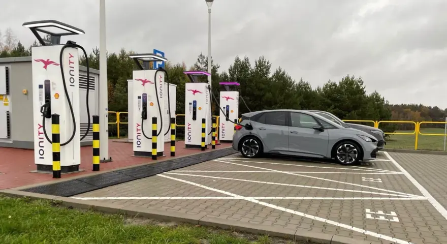 Szara Skoda Enyaq ładuje się na stacji Ionity Polska. Obok kolejne ładowarki i samochody elektryczne.