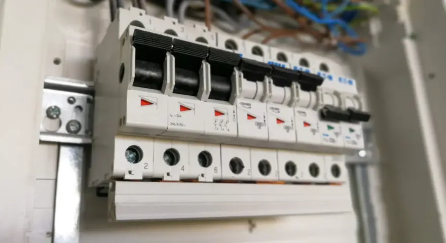 Szereg wyłączników nadprądowych w rozdzielnicy elektrycznej. Widać ich charakterystykę i oznaczenia prądowe.