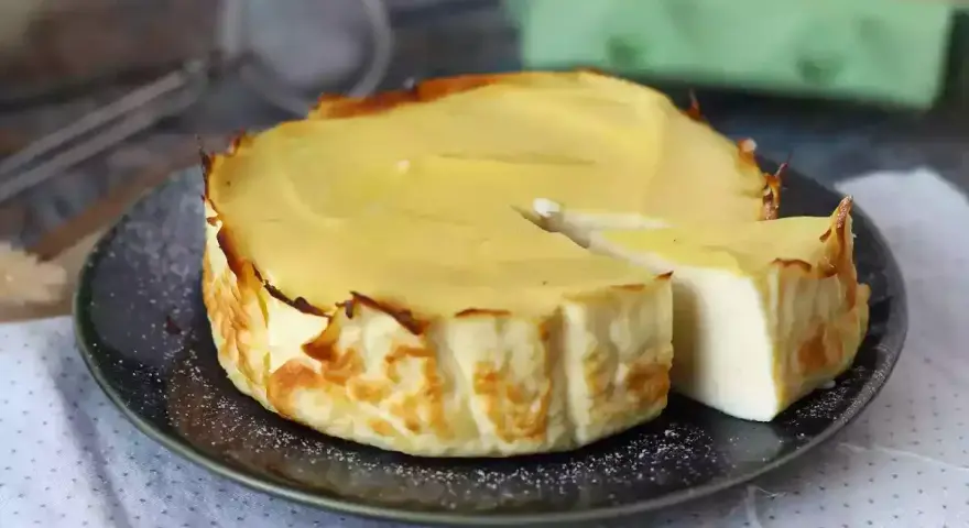 En krämig ricotta cheesecake, perfekt för ett enkelt ricotta recept. En bit är uppskuren och visar den lena insidan.