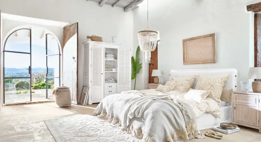 Elegantes dormitorio ideas con cama grande, armario blanco y puertas abiertas a un paisaje soleado.