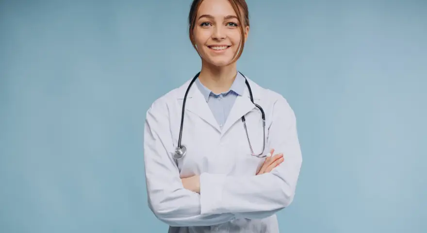 Uśmiechnięta lekarka w białym kitlu ze stetoskopem, zastanawia się, ile trwa specjalizacja z psychiatrii.