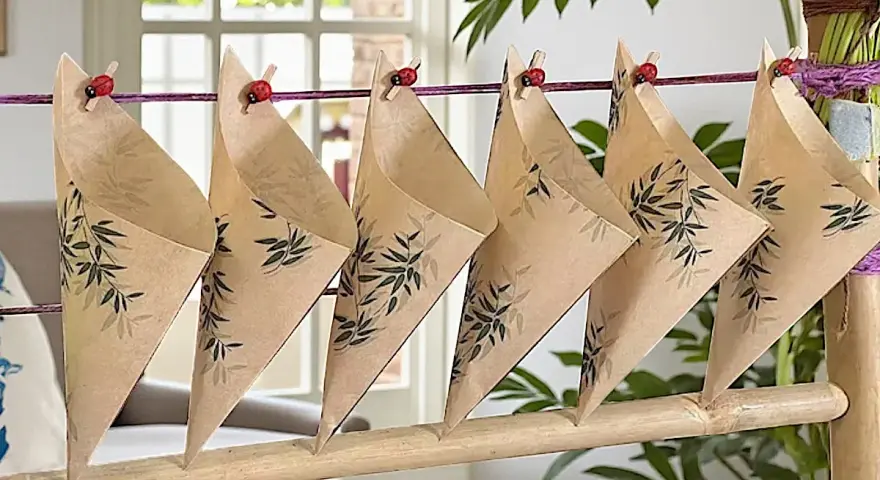 Cucuruchos de papel con diseño de bambú, colgados con pinzas de mariquita. Ideas para hacer cucuruchos de papel.