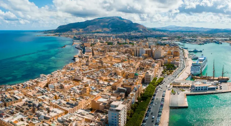 Widok na Trapani, Sycylia. Miasto z widokiem na turkusowe morze i góry. Zobacz, co warto zobaczyć w Trapani: port z luksusowym rejsem i zabytkowymi żaglowcami.