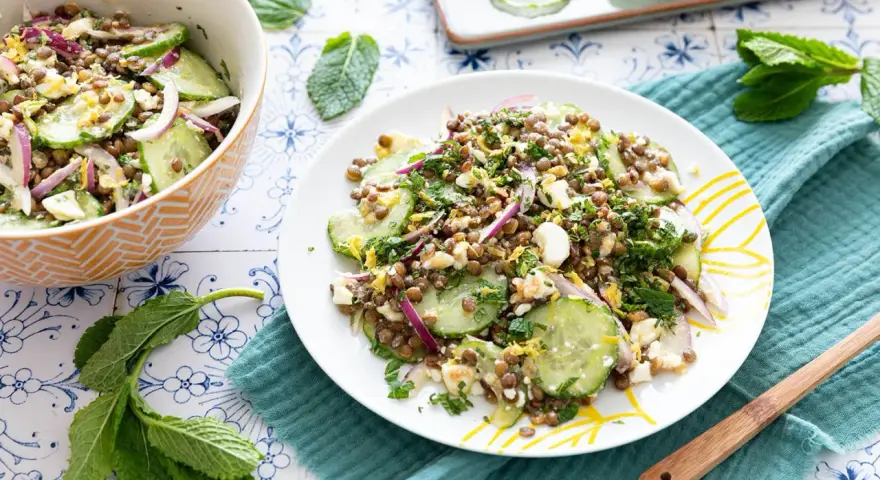 Salade de lentilles, concombre, oignon rouge et feta émiettée, garnie d'herbes fraîches. Un délice léger et coloré.