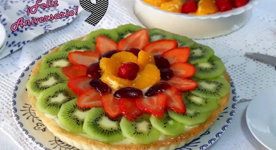 ¡Feliz Aniversario! Una deliciosa tarta de frutas con kiwi, fresas, naranja y uvas.