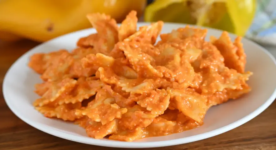 Farfalle condite con una cremosa salsa ai peperoni, un piatto colorato e gustoso.