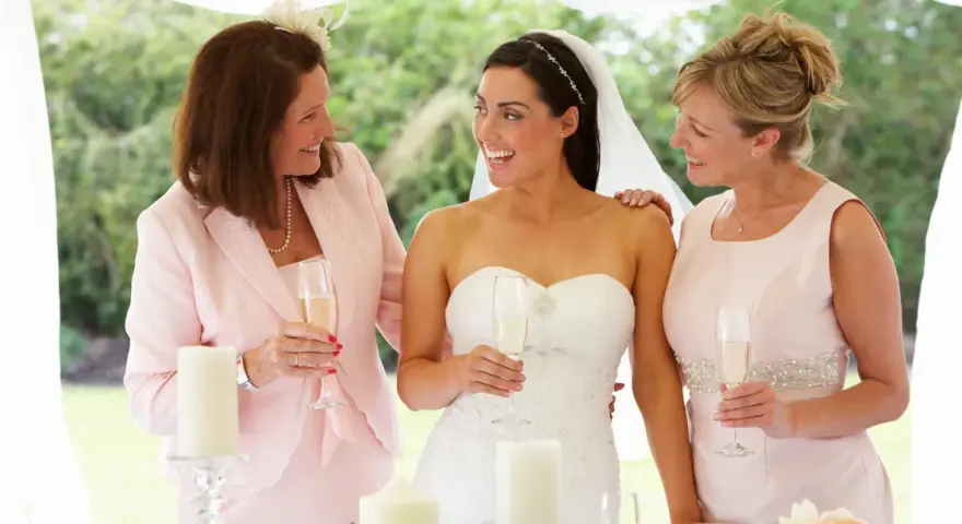Panna młoda z mamą i druhną, toast szampanem. Dobry wedding planner cena to klucz do udanego wesela.