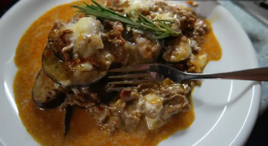 Herzhafte Auberginen-Hackfleisch-Auflauf, inspiriert von Omnia Rezepte, mit geschmolzenem Käse und Rosmarin garniert.