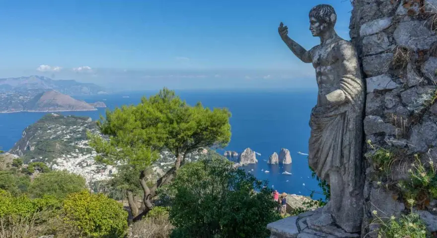 Statua antica domina il panorama mozzafiato di Capri. Un invito a scoprire cosa visitare a Capri, tra mare blu e Faraglioni.